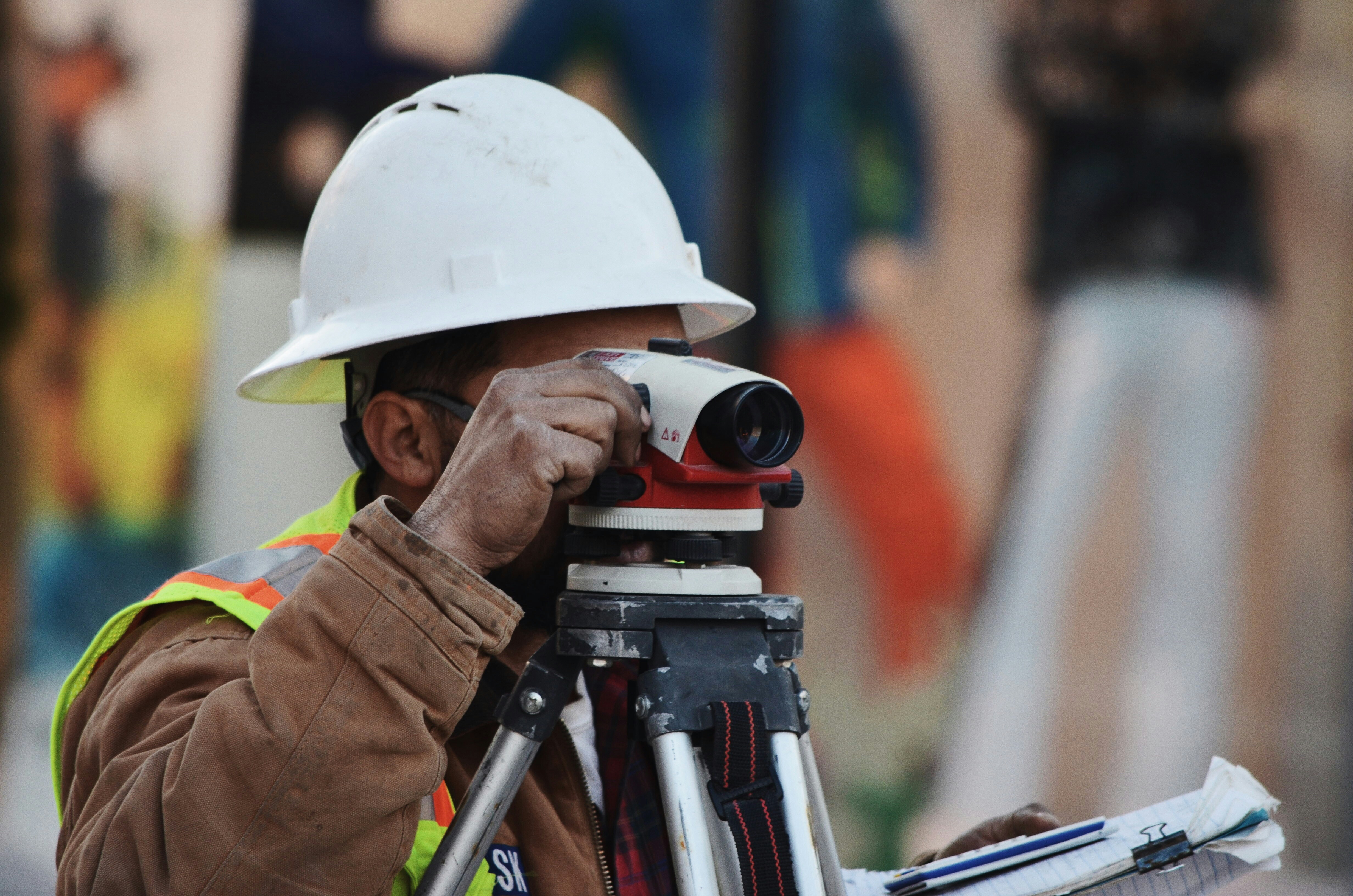 Topógrafo com equipamento de precisão em canteiro de obras e implantação — Bassini Engenharia